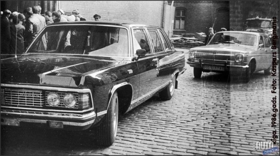 1986.oktobris. Rīga. Pirmā „GAZ 14” Latvijā. Limuzīns no LSPR komunistiskās partijas garāžas. Numura zīme uz priekšējā pampera nav pat uzstādīta. Pavadošais automobilis „GAZ 24” no Valsts drošības komitejas (KGB).  Šāda eskorta pavadībā uz Doma baznīcu, klausīties ērģeļmūzijas koncertu tika atvests kāds augsta ranga kompartijas „čiekurs” no Maskavas. 
Foto no Kaspara Bergmaņa arhīva.
