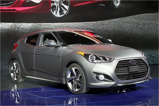 Hyundai Veloster Turbo. Līdz šim korejiešu sportiskā kupeja bija pieejama ar visai necilu 140 ZS benzīna motoru, taču uz Detroitu Hyundai atvedis krietni agresīvāku modifikāciju – Veloster Turbo, kurai iebūvēts 210 ZS turbo agregāts.